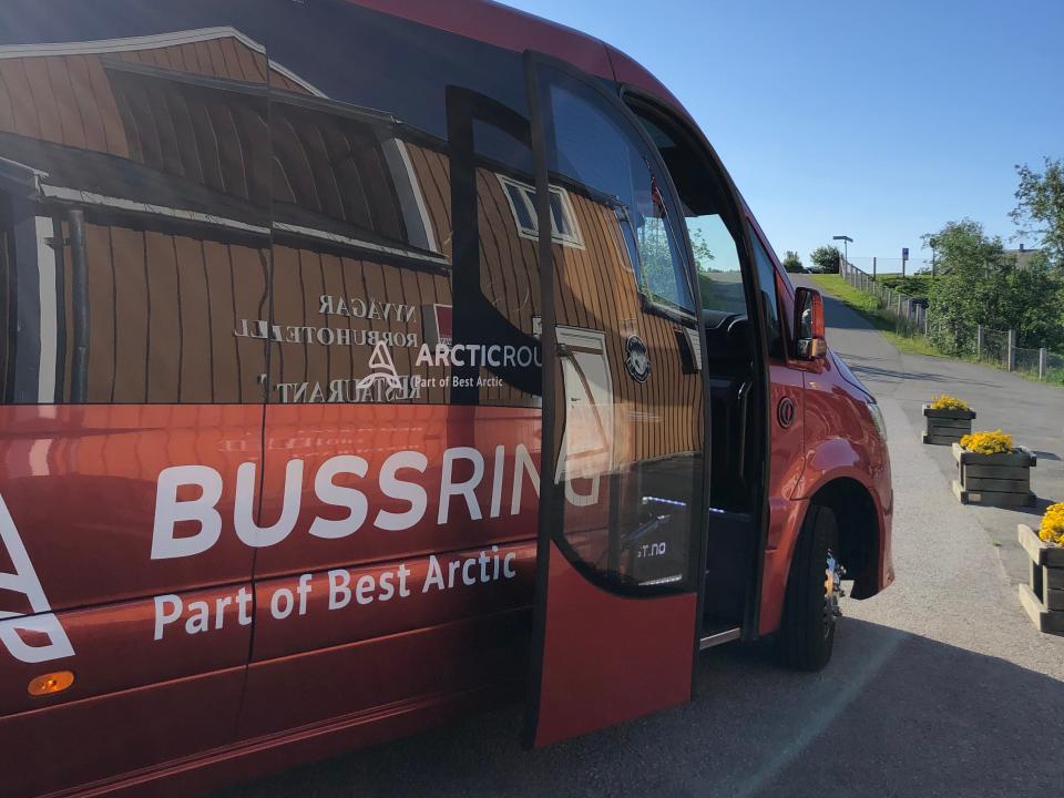 A red Bussring bus with the door open.