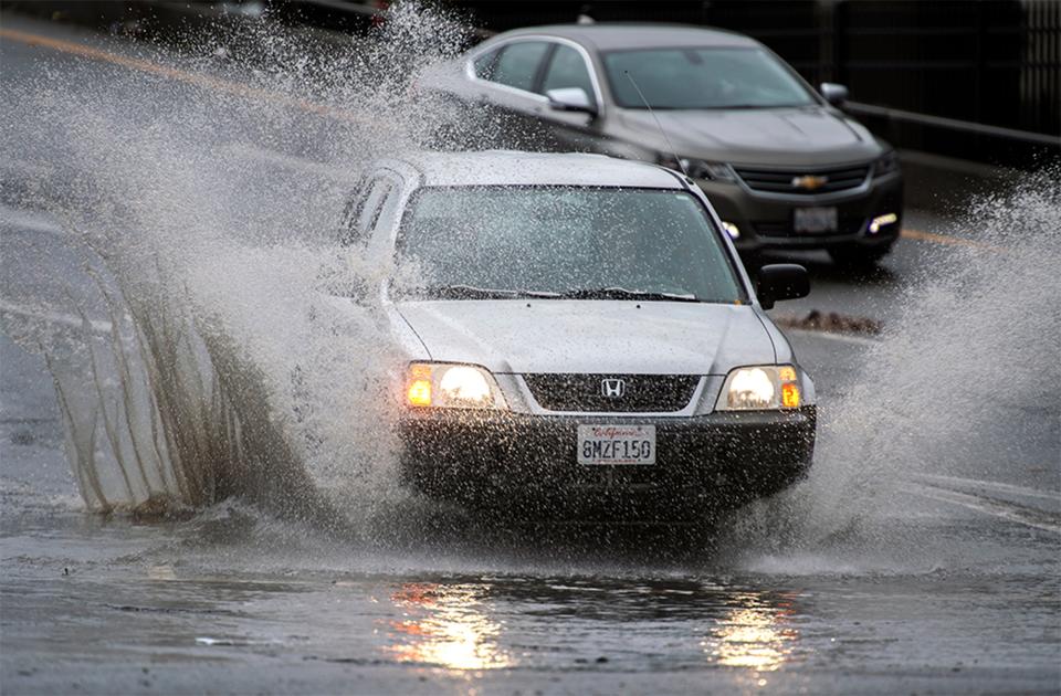 A vehicle splashes through a large puddle at the bottom of the westbound Crosstown Freeway off ramp Dec. 23 at El Dorado Street in downtown Stockton.