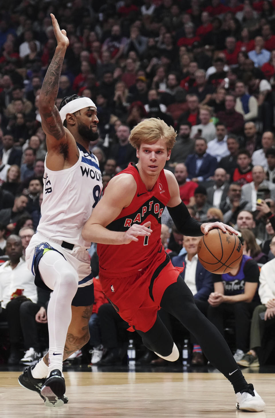 Toronto Raptors' Gradey Dick (1) drives around Minnesota Timberwolves' Nickeil Alexander-Walker (9) during the first half of an NBA basketball game Wednesday, Oct. 25, 2023, in Toronto. (Nathan Denette/The Canadian Press via AP)