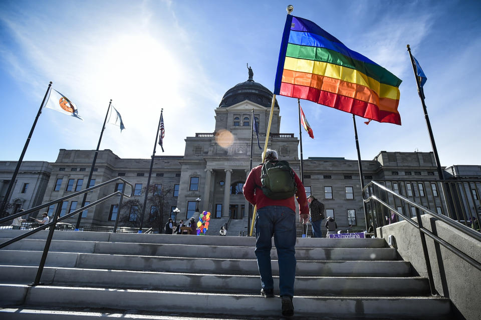 FILE - In this March 15, 2021, file photo, demonstrators gather on the steps of the Montana State Capitol protesting anti-LGBTQ+ legislation in Helena, Mont. It's been a month since a Montana judge temporarily blocked enforcement of a state law that required transgender people to undergo surgery before they could change their gender on their birth certificate, and the state still isn't in compliance with the court order, the ACLU of Montana said. (Thom Bridge/Independent Record via AP, File)