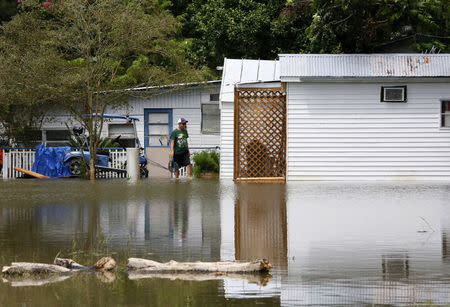 A man surveys a flooded home in St. Amant, Louisiana. REUTERS/Jonathan Bachman