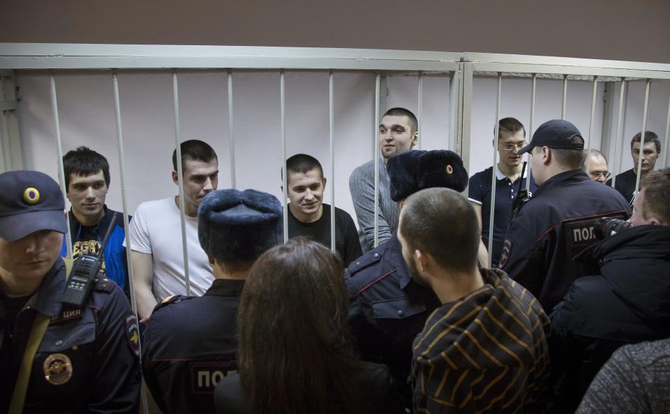 Defendants stand behind bars in a cage at a court room in Moscow, Russia, Monday, Feb. 24, 2014, where hearings started against opposition activists detained on May 6, 2012 during a rally at Bolotnaya Square. A Moscow judge on Friday, Feb. 21, 2014, convicted eight anti-government protesters of rioting during a 2012 protest against Vladimir Putin, following a trial seen as part of the Kremlin's efforts to stifle dissent. (AP Photo/Alexander Zemlianichenko)