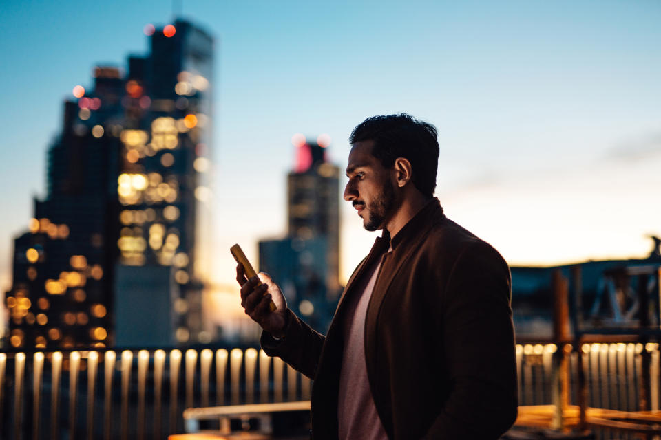 Un hombre mira su teléfono.