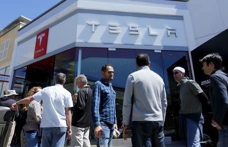 People wait in line at a Tesla Motors dealership to place deposits on the electric car company's mid-priced Model 3 in La Jolla, California, March 31, 2016. REUTERS/Mike Blake