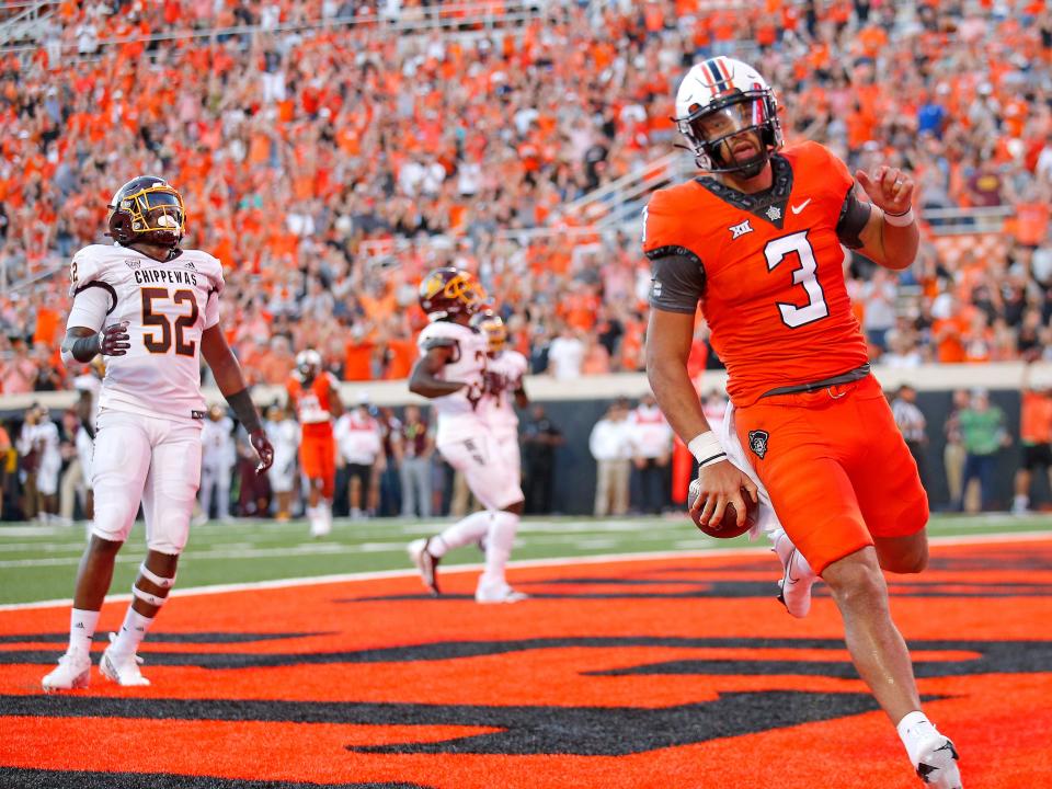 Oklahoma State quarterback Spencer Sanders (3) runs into the end zone for touchdown as Central Michigan linebacker Dakota Cochran (52) reacts in the second quarter of a 58-44 win Thursday night in Stillwater.