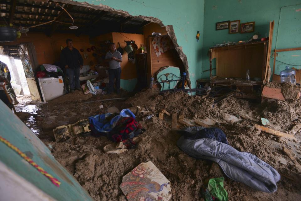 People stand in a house flooded by mud after a mountain landslide in Altotonga in Veracruz state, along Mexico's Gulf coast, September 16, 2013. Two powerful storms pummeled Mexico as they converged from the Pacific and the Gulf on Monday, killing at least 41 people and forcing the evacuation of tens of thousands amid some of the worst flooding in decades. Tropical Depression Ingrid battered Mexico's northern Gulf coast, while the remnants of Tropical Storm Manuel lashed the Pacific coast, inundating the popular beach resort of Acapulco, the U.S. National Hurricane Center (NHC) said. REUTERS/Oscar Martinez (MEXICO - Tags: DISASTER ENVIRONMENT)