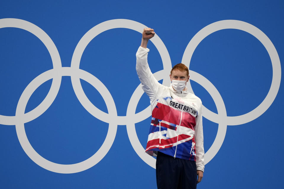 Tom Dean of Britain celebrates on the podium after winning the final of the men's 200-meter freestyle at the 2020 Summer Olympics, Tuesday, July 27, 2021, in Tokyo, Japan. (AP Photo/Martin Meissner)