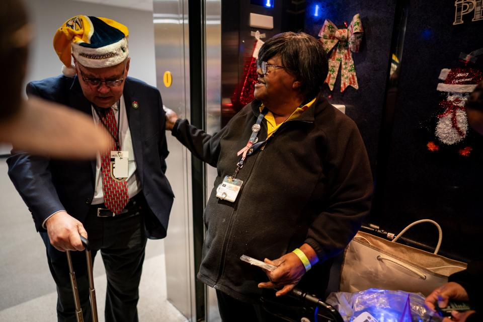 Elevator attendant Martha Booker, center, greets Predators radio broadcaster Pete Weber, left, before a game between the Nashville Predators and the Dallas Stars at Bridgestone Arena in Nashville, Tenn., Saturday, Dec. 23, 2023.