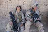 BOLDOC, AFGHANISTAN - NOVEMBER 23: Lance Corporal Luz Lopez, 21, (L) a US Marine with the FET ( Female Engagement Team) 1st Battalion 8th Marines, Regimental Combat team II and Riane Donoho ,21 (R) take a rest during a village medical outreach November 23, 2010 in Boldoc, in Helmand province , Afghanistan. There are 48 women presently working along the volatile front lines of the war in Afghanistan; deployed as the second Female Engagement team participating in a more active role, gaining access where men can't. The women, many who volunteer for the 6.5 month deployment, take a 10 week course at Camp Pendleton in California where they are trained for any possible situation, including learning Afghan customs and basic Pashtun language. (Photo by Paula Bronstein/Getty Images)