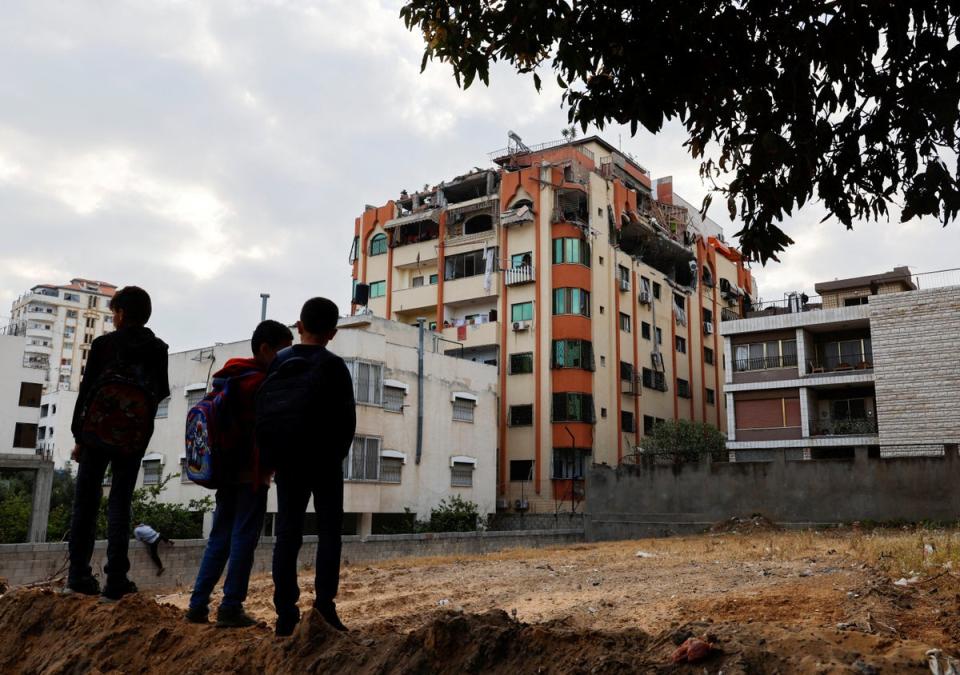 Children stand near a damaged building in the aftermath of Israeli military strikes (REUTERS)