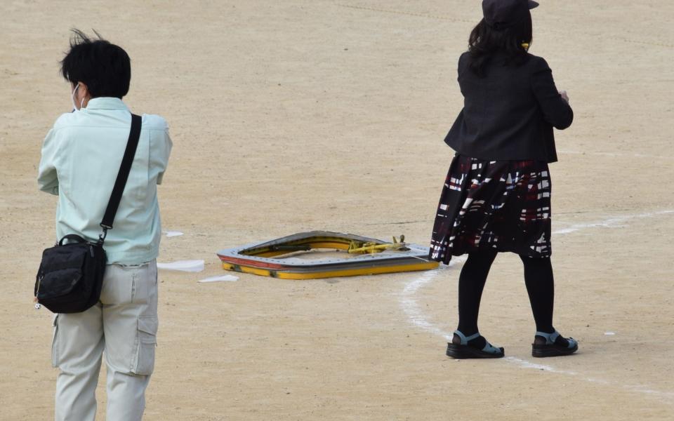 The fallen window frame of U.S. military aircraft is seen on the ground at an elementary school in Ginowan, Okinawa  - Okinawa Times via Kyodo News