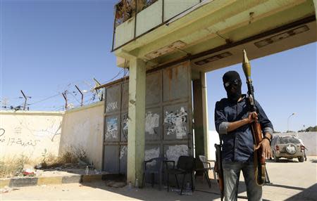 A militia stands guard in front of the entrance to the February 17 militia camp after Libyan irregular forces clashed with them in the eastern city of Benghazi May 16, 2014. REUTERS/Esam Omran Al-Fetori