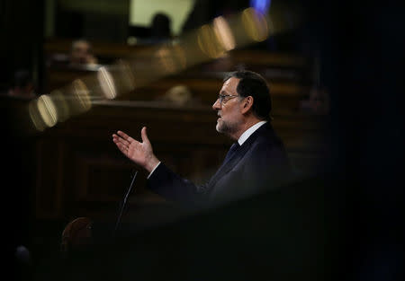 Spain's acting Prime Minister Mariano Rajoy delivers a speech during the investiture debate at the Parliament in Madrid, Spain October 27, 2016. The pattern across the frame is the reflection of light on a railing. REUTERS/Sergio Perez