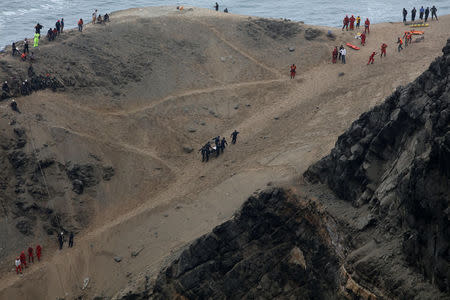 Rescue workers carry victims after a bus crashed with a truck and careened off a cliff along a sharply curving highway north of Lima, Peru, January 3, 2018. REUTERS/Guadalupe Pardo