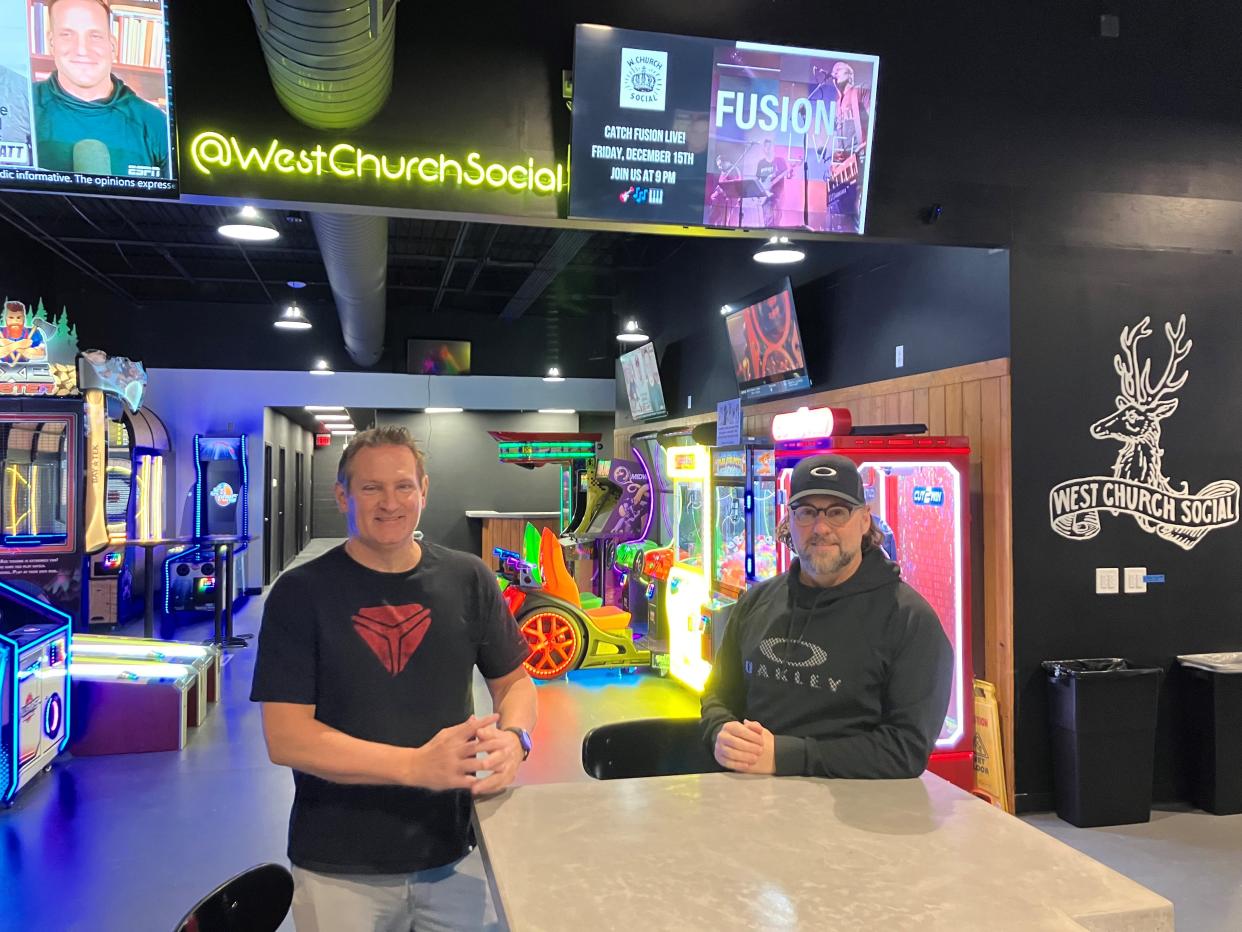 West Church Social co-owners Matt Maynard (left) and Brian Hoy in front of the arcade games at the bar.