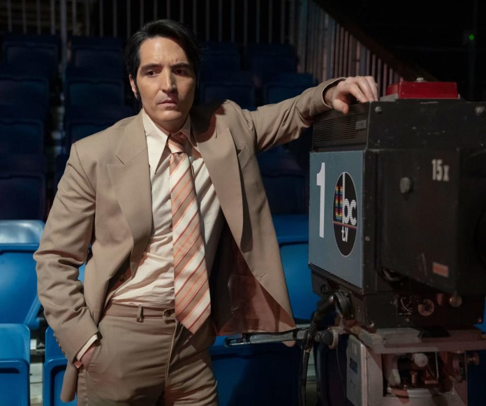 David Dastmalchian leans on a camera in a still from ‘Late Night With the Devil’