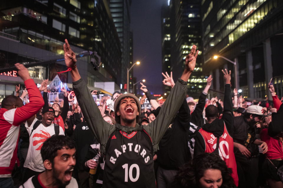 Toronto Raptors fans react as they watch Game 6 of the NBA basketball Eastern Conference finals between the Toronto Raptors and Milwaukee Bucks, on a screen outside Scotiabank Arena, in Toronto on Saturday, May 25, 2019. (Chris Young/The Canadian Press via AP)