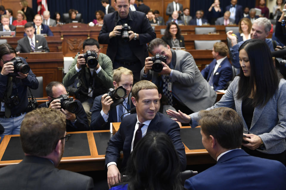 Facebook Chief Executive Officer Mark Zuckerberg, front center, turns back and smiles after arriving for a hearing before the House Financial Services Committee on Capitol Hill in Washington, Wednesday, Oct. 23, 2019. (AP Photo/Susan Walsh)