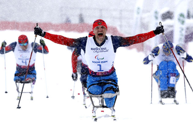 <div><span>GLORY - Russia's Roman Petushkov celebrates his gold medal during the men's 1 km sprint cross-country sitting at the 2014 Sochi Paralympic Winter Games in Rosa Khutor.</span></div>