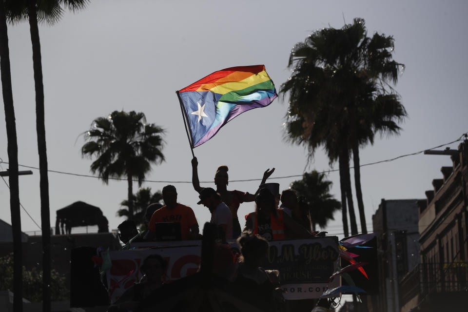 Revelers, including one holding up a Puerto Rico rainbow flag, celebrate during the Tampa Pride Parade.