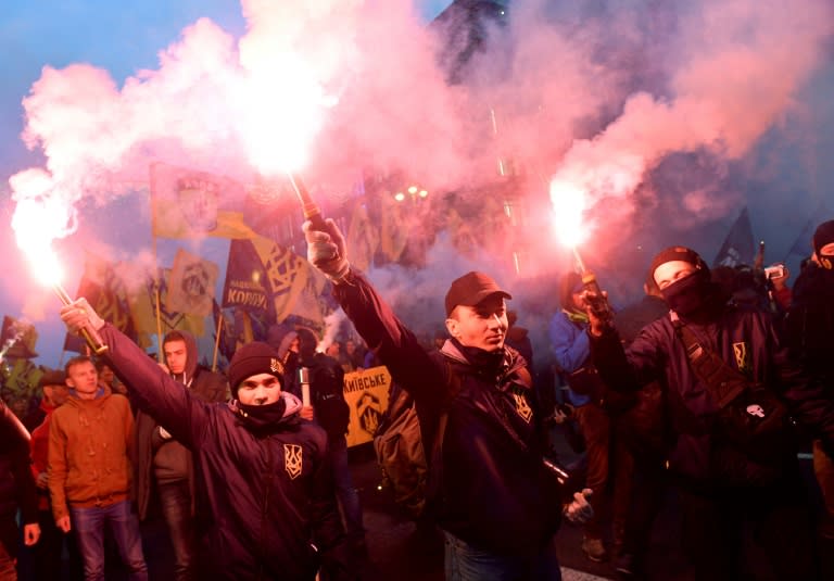 Ukrainian far-right activists hold flares during a march which also remembered the country's fallen soldiers in the east