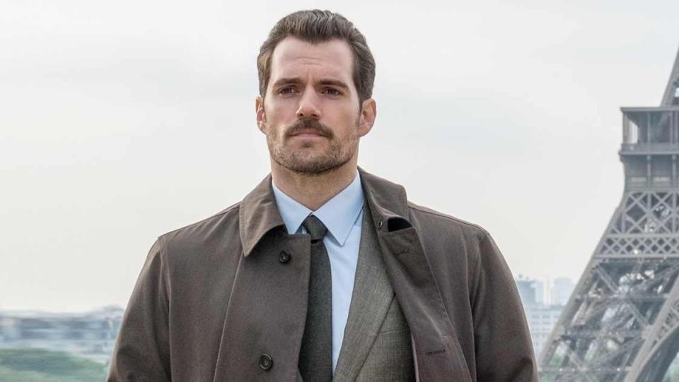 Henry Cavll in a jacket and suit with a beard near the Eiffel Tower in Mission: Impossible - Fallout