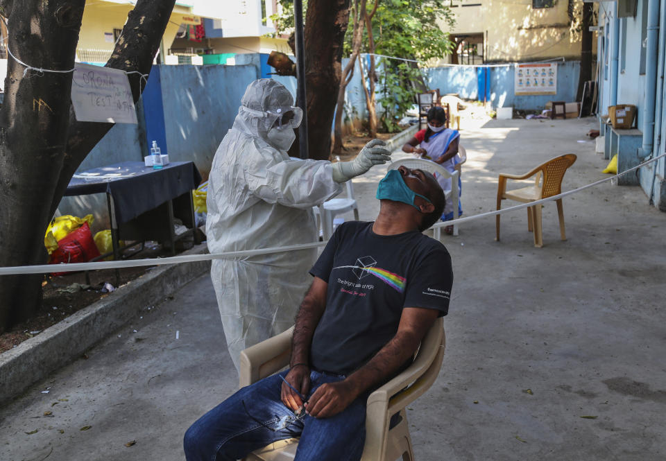 A health worker takes a nasal swab sample at a COVID-19 testing center in Hyderabad, India, Sunday, Dec. 13, 2020. (AP Photo/Mahesh Kumar A.)