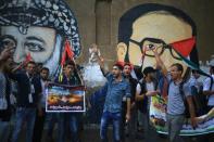 Palestinian students shout anti-Israeli slogans as they demonstrate next to the murals of Yasser Arafat (left) and Fathi Shaqaqi during a demonstration in Gaza City, on October 7, 2015