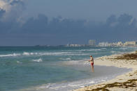 A tourist fishes from the shore in Cancun, Mexico, Thursday, June 11, 2020. An irony of the coronavirus pandemic is that the idyllic beach vacation in Mexico in the brochures really does exist now: the white sand beaches are sparkling clean and empty on the Caribbean coast. (AP Photo/Victor Ruiz)