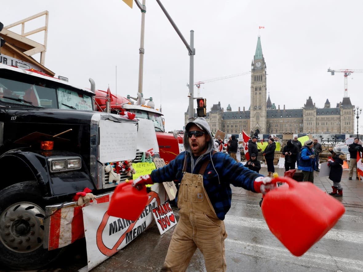 A demonstrator screams and bangs gas canisters together during the ongoing convoy protest in Ottawa on Feb. 10, 2022. (Blair Gable/Reuters - image credit)