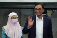 Malaysia opposition leader Anwar Ibrahim and his wife Wan Azizah Wan Ismail react after a news conference in Kuala Lumpur