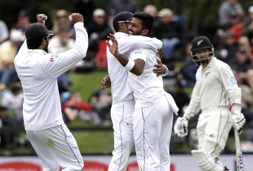 Sri Lanka's Lahiru Kumara, second right, is congratulated by teammates after taking the wicket of New Zealand's Colin de Grandhomme during play on day one of the second cricket test between New Zealand and Sri Lanka at Hagley Oval in Christchurch, New Zealand, Wednesday, Dec. 26, 2018. (AP Photo/Mark Baker)