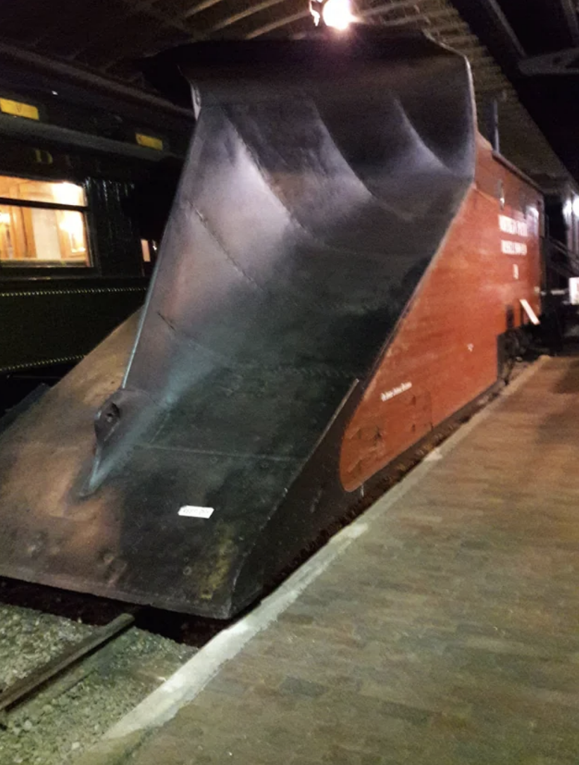 Front view of a vintage streamlined steam locomotive at a railway station at night