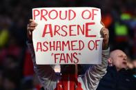 An Arsenal fan holds up a sign in a show of support for Arsenal's French manager Arsene Wenger during the English Premier League match between Arsenal and Norwich in London on April 30, 2016