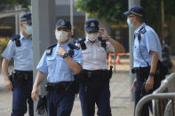 Police officers stand guard as they wait for Tong Ying-kit's arrival at a court in Hong Kong Tuesday, July 27, 2021. Hong Kong High Court will deliver verdict in the afternoon for the first person charged under Hong Kong's National Security Law. Tong was arrested in July 2020 after driving his motorbike into a group of police officers while carrying a flag bearing the protest slogan “Liberate Hong Kong." He was charged with inciting separatism and terrorism. (AP Photo/Vincent Yu)