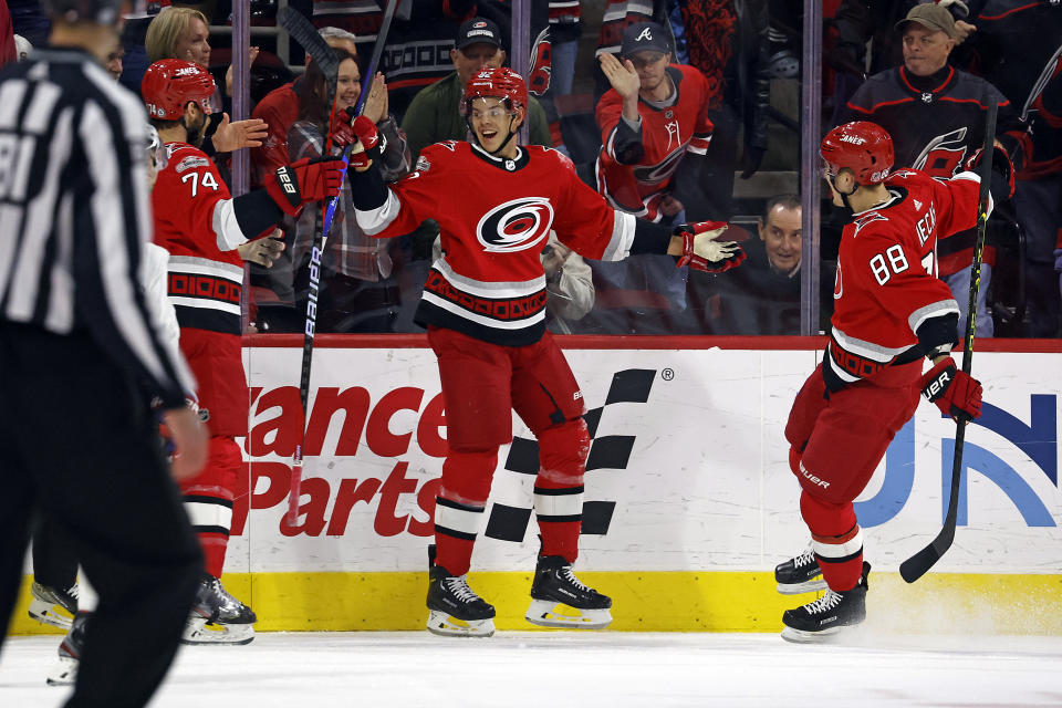 Carolina Hurricanes' Jesperi Kotkaniemi (82) celebrates after his goal with teammates Jaccob Slavin (74) and Martin Necas (88) during the first period of an NHL hockey game against the Montreal Canadiens in Raleigh, N.C., Thursday, Feb. 16, 2023. (AP Photo/Karl B DeBlaker)