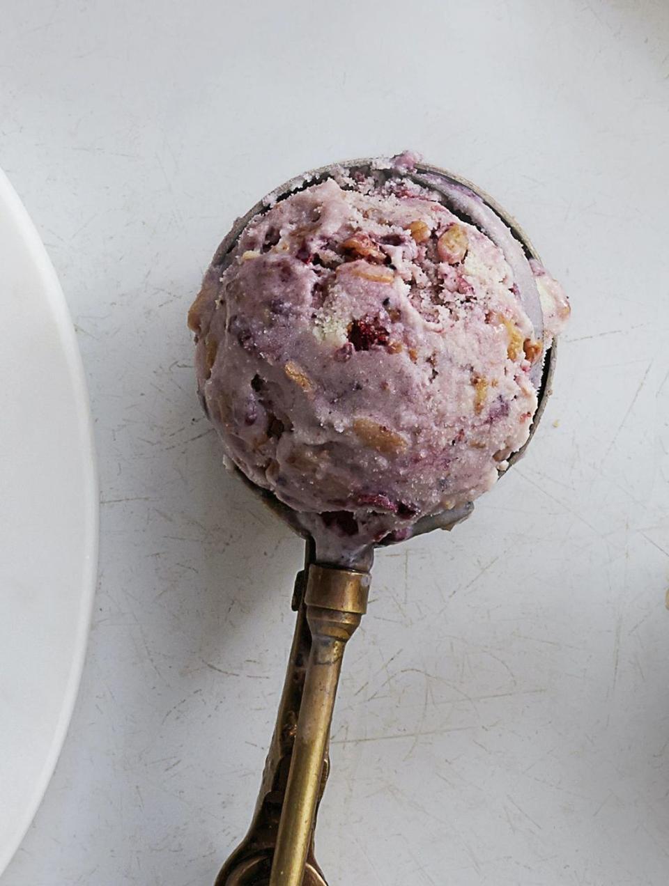 a scoop of blackberry buckle ice cream in an ice cream scooper