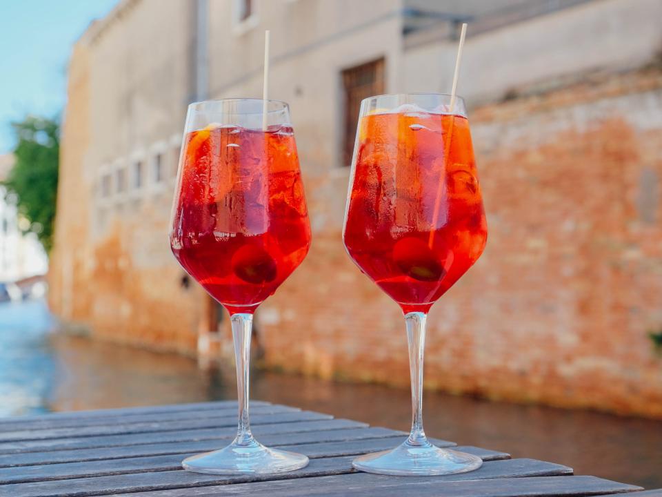 two Aperol spritzes on an outdoor table