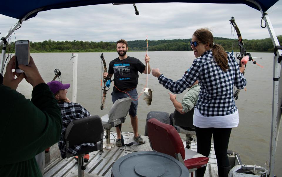 Matt Mehill of Chicago, Ill., center, shows off the silver carp he shot with his archery skills on a trip to the Illinois River with his friends, from left, Nicole Dowdall, Sarah Hinman, Jimmy Laria and Ellie Kenny. Nate Wallick's Peoria Carp Hunters business on the offers bow fishing from the fantail of The Carpocalypse, a modified pontoon boat, on Saturday, Sept. 8, 2018. Wallick's videos of his creative carp hunting techniques are some of the most popular on the internet.