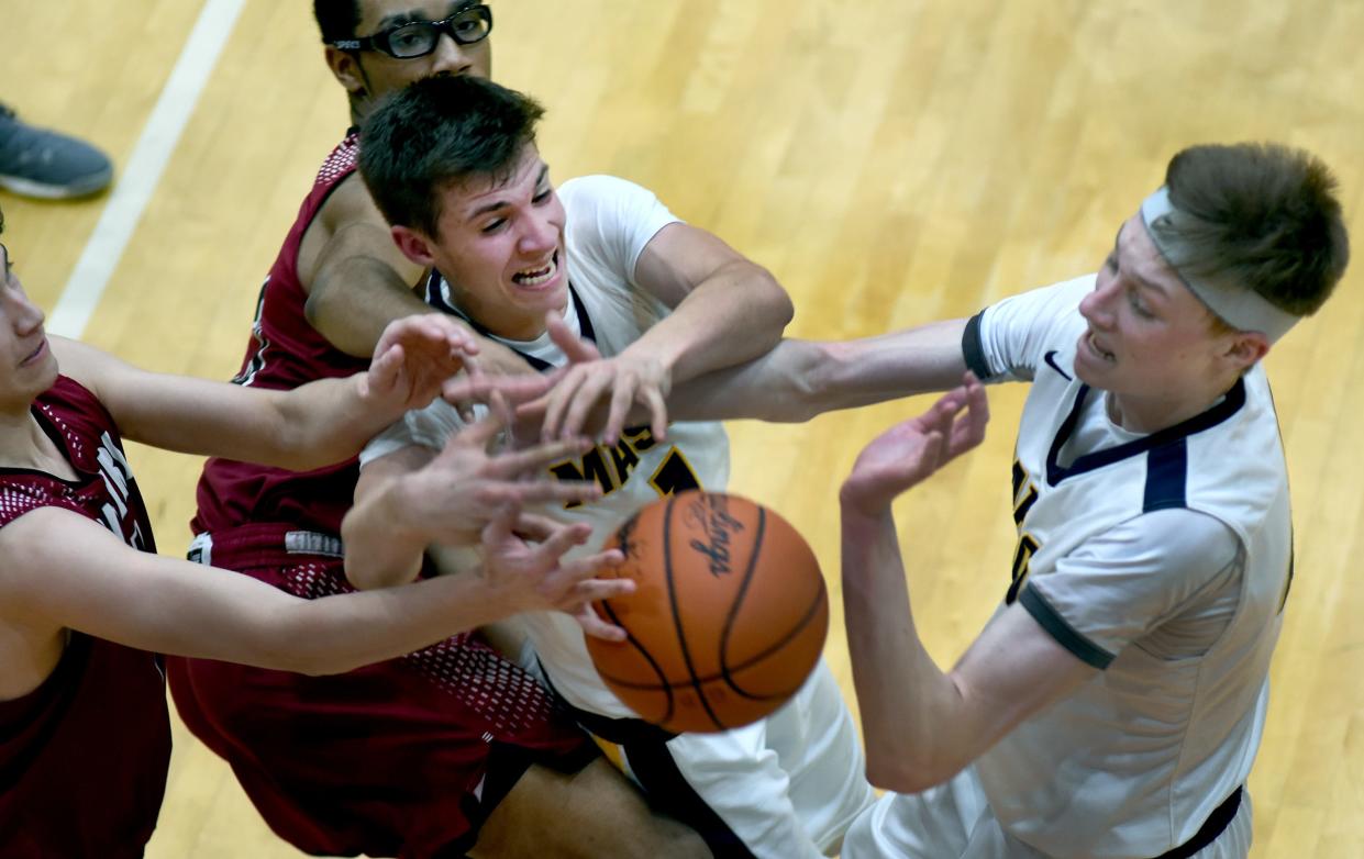 Joe Liedel (center) and John Sweeney of Erie Mason battle for a rebound during a game in 2019. They were teammates again this season for Kalamazoo Valley Community College.