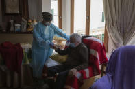 Nurse Pilar Rodríguez comforts Antonio Comas Serra, 80, after receiving the vaccine against COVID-19 at his home in the town of Sa Pobla on the Spanish Balearic Island of Mallorca, Spain, Friday, April 30, 2021. While thousands flock daily at health clinics and ad-hoc vaccination points across Spain, health workers also fan out across the country to take shots to some of those who are the most vulnerable to the coronavirus. (AP Photo/Francisco Ubilla)