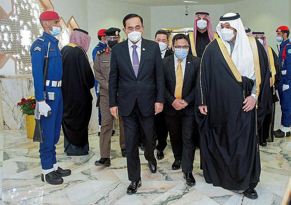 In this photo released by Saudi Press Agency, SPA, Thai Prime Minister Prayuth Chan-ocha, front left, talks to Prince Mohammed bin Abdulrahman bin Abdulaziz, Deputy Governor of Riyadh, Tuesday, Jan. 25, 2022. Thailand's prime minister arrived in Saudi Arabia on Tuesday for the first high-level meeting since relations between the nations soured three decades ago over a sensational jewelry heist that led to a diplomatic row and string of mysterious killings. (Saudi Press Agency via AP)