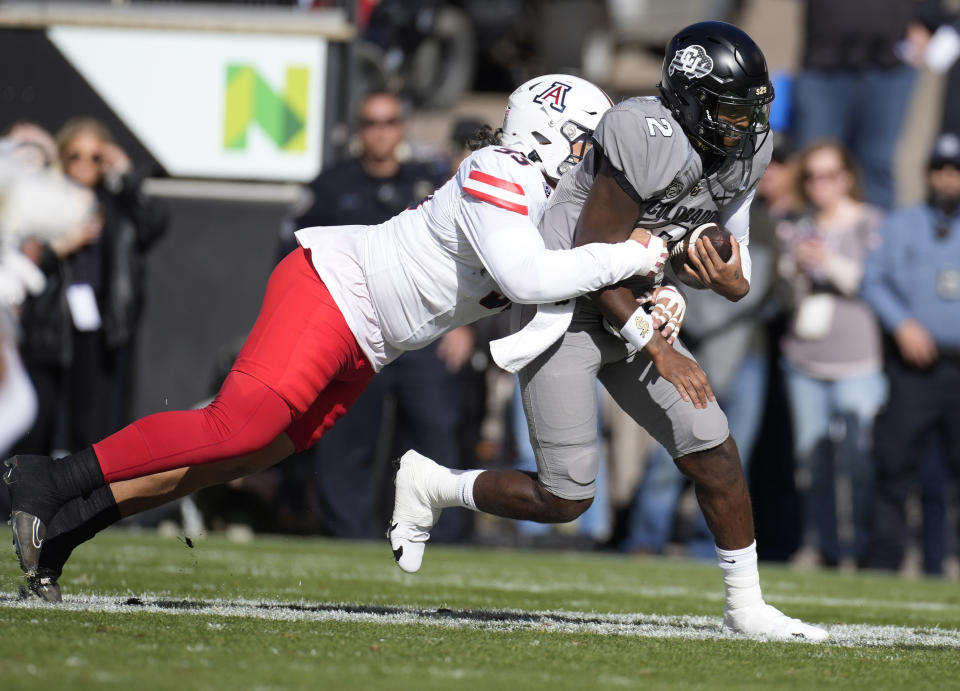 Arizona defensive back Martell Irby, left, sacks Colorado quarterback Shedeur Sanders in the first half of an NCAA college football game on Saturday, Nov. 11, 2023, in Boulder, Colo. (AP Photo/David Zalubowski)