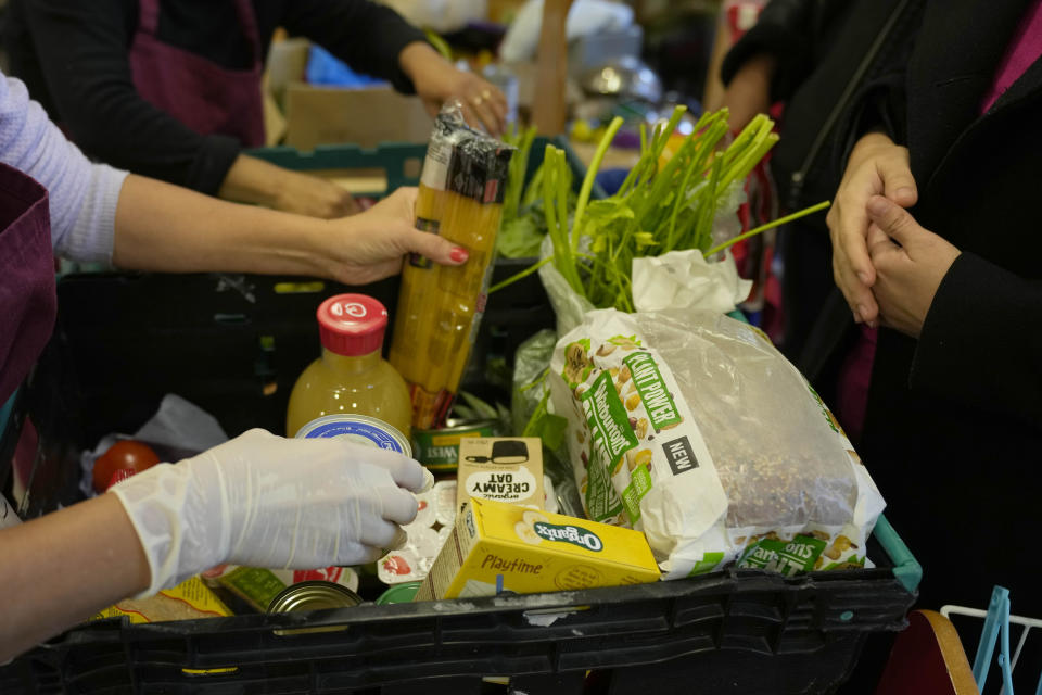 Volunteers pack boxes with food for customers at the community food pantry in Vauxhall, London, Wednesday, Nov. 16, 2022. Just three weeks after taking office, British Prime Minister Rishi Sunak faces the challenge of balancing the nation's finances while helping millions of people slammed by a cost-of-living crisis as Russia's war in Ukraine pushes up energy prices and slows economic growth. Treasury chief Jeremy Hunt will deliver the government’s plan for tackling a sputtering economy in a speech to the House of Commons on Thursday. (AP Photo/Frank Augstein)