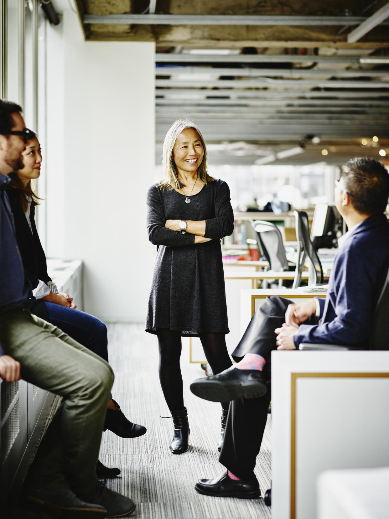 Smiling mature businesswoman leading team meeting in office