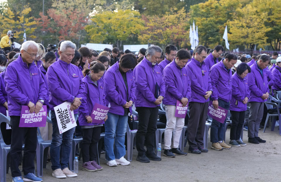 Family members of the victims offer prayers during a rally to mark the first anniversary of the harrowing crowd surge that killed about 160 people in a Seoul alleyway, at the Seoul Plaza in Seoul, South Korea, Sunday, Oct. 29, 2023. (AP Photo/Ahn Young-joon)