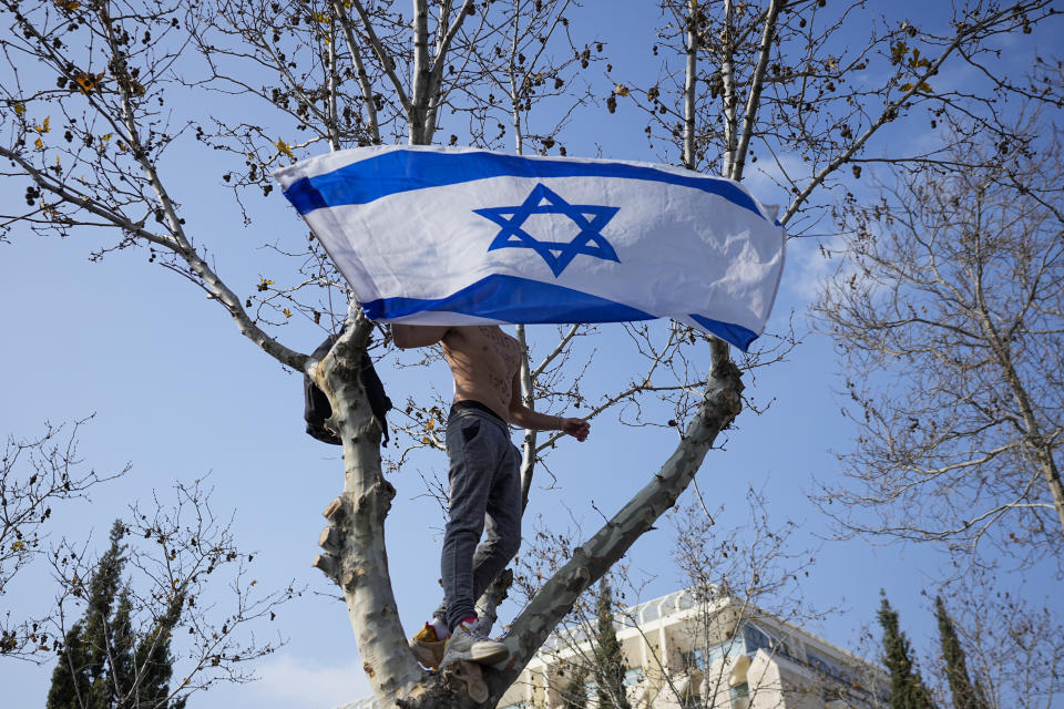 An Israeli protests against plans by Prime Minister Benjamin Netanyahu's new government to overhaul the judicial system outside the Knesset, Israel's parliament in Jerusalem, Monday, Feb. 20, 2023. Israel's government is pressing ahead with its contentious plan to overhaul the country's legal system. A vote in parliament on Monday is due despite an unprecedented uproar that has included mass demonstrations, warnings from military and business leaders and calls for restraint from the U.S. (AP Photo/Ohad Zwigenberg)