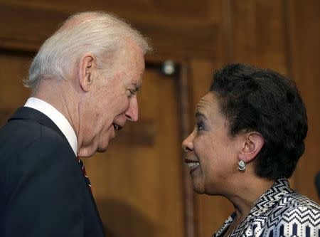 Loretta Lynch (R) smiles after being sworn in as the 83rd U.S. Attorney General, and the first black woman to occupy the post, by Vice-President Joe Biden at the Justice Department in Washington April 27, 2015. REUTERS/Gary Cameron