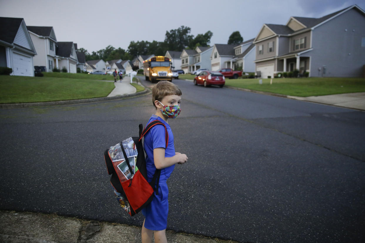 A 7-year-old boy wearing a mask waits at the bus stop on Aug. 3, the first day of school in Dallas, Georgia. (Photo: AP Photo/Brynn Anderson)