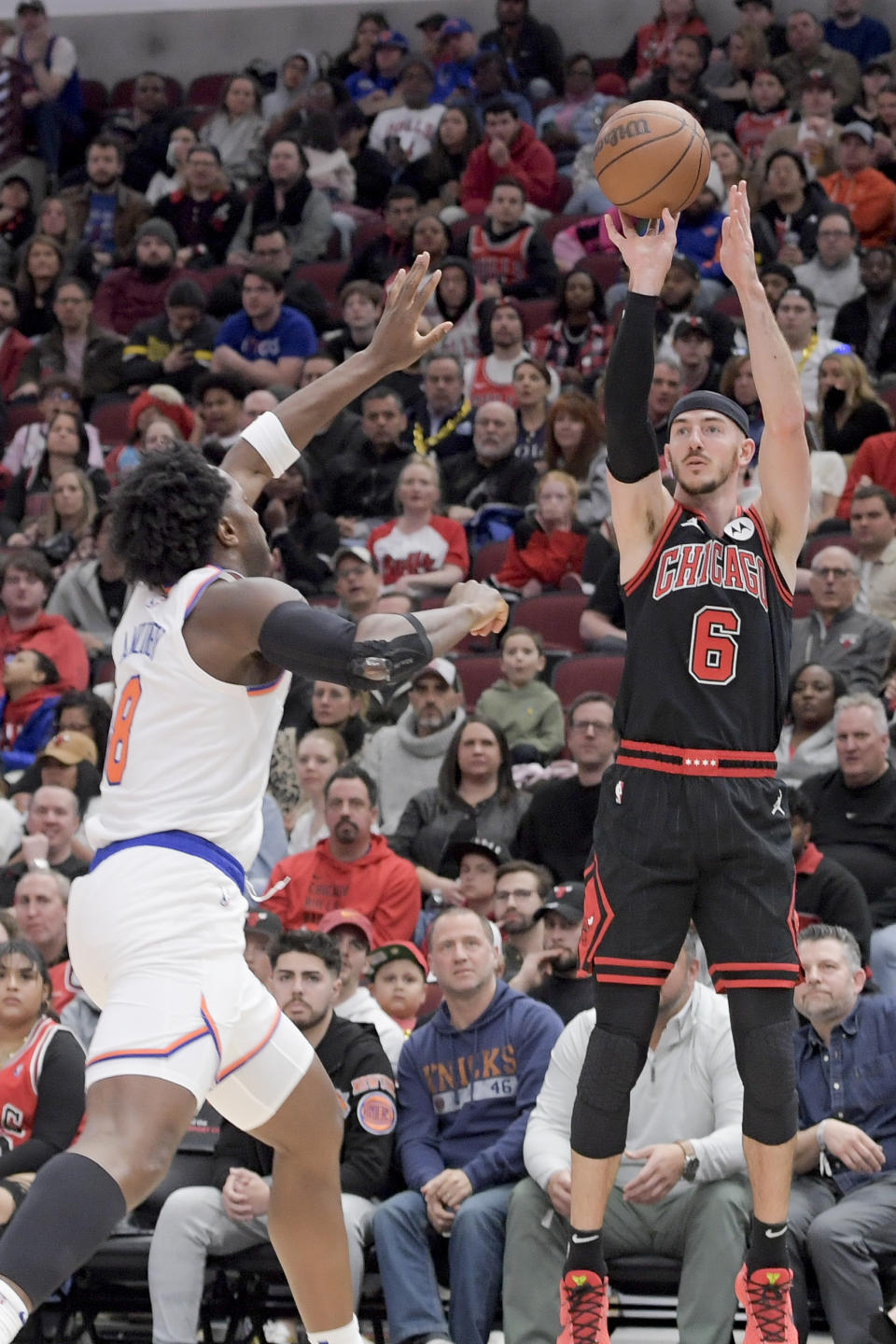 CORRECTS TO OG ANUNOBY, INSTEAD OF DAQUAN JEFFRIES - Chicago Bulls' Alex Caruso (6) shoots over New York Knicks' OG Anunoby (8) during the third quarter of an NBA basketball game in Chicago, Friday, April 5, 2024. Bulls defeat the Knicks 108-100. (AP Photo/Mark Black)